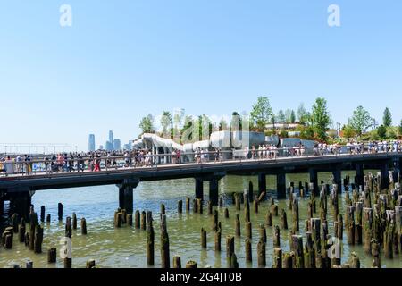 Folle di turisti e visitatori che partono e arrivano al nuovo parco pubblico gratuito Little Island al molo 55 sul fiume Hudson. Resti di un vecchio molo per Foto Stock