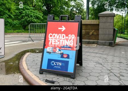 Il test di Covid-19 con una freccia indirizza i visitatori alla sede del centro di test mobile di coronavirus. Maschera facciale usata a terra. - New York, Stati Uniti d'America - 2021 Foto Stock