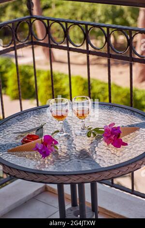 Cocktail estivi fatti in casa con fiori rosa di bougainvillea su un tavolo di vetro. Avere un concetto creativo di riposo. Estate fiori surreali luminosi e rinfreschi Foto Stock
