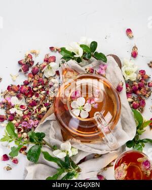 Tè alle rose con tazze e teiera sul dorso grigio chiaro. Vista dall'alto Foto Stock