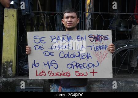 Un dimostratore ha un segno che recita "sangue dell'eroe colombiano che attraversa il suolo colombiano, non più oppressione", poiché migliaia di contadini, indigeni e persone impegnati nell'accordo di pace di Meta e Guaviare hanno deciso di lasciare i loro territori nella città di Villavicencio, Colombia per unirsi allo sciopero nazionale 'Paro Nacional' proteste anti-governo in Colombia contro il governo del presidente Ivan Duque, disuguaglianze e disordini causati da abuso di autorità da parte della polizia. Il 19 maggio 2021. Foto Stock