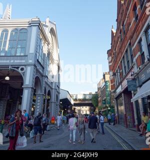 Londra, Grande Londra, Inghilterra - Giugno 12 2021: Persone che camminano per la strada accanto al Borough Market (a sinistra) Foto Stock