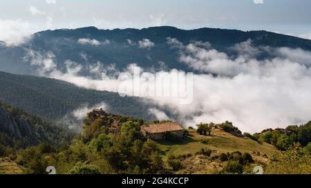 Sant Llorenç dels Porxos Hermitage nei monti Rasos de Peguera con le nuvole basse (Berguedà, Catalogna, Spagna, Pirenei) Foto Stock