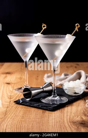 Gibson martini cocktail con cipolle su tavolo di legno Foto Stock