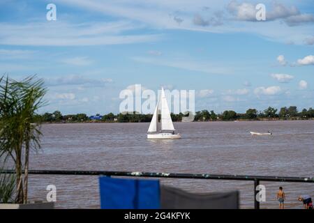 ROSARIO, ARGENTINA - 19 maggio 2021: Selezionato fuoco di barca a vela bianca che naviga il fiume Parana con l'isola sullo sfondo in una giornata di sole con Foto Stock