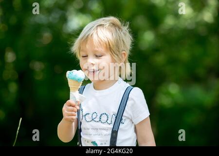 Bambino, ragazzo carino, mangiare gelato nel parco, all'aperto Foto Stock