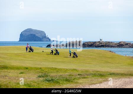 Tre golfisti su un campo da golf a North Berwick con Bass Rock sullo sfondo. Foto Stock