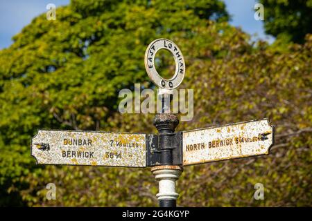 Un vecchio cartello di metallo in Whitekirk che punta verso Dunbar e Berwick Nord Foto Stock