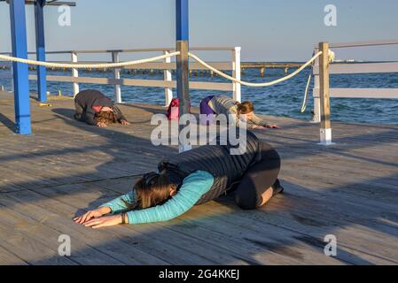 Donne che praticando yoga in una fattoria di cozze nella baia di Alfacs nel delta dell'Ebro (Tarragona, Catalogna, Spagna) ESP: Participantes en actividad de yoga (España) Foto Stock