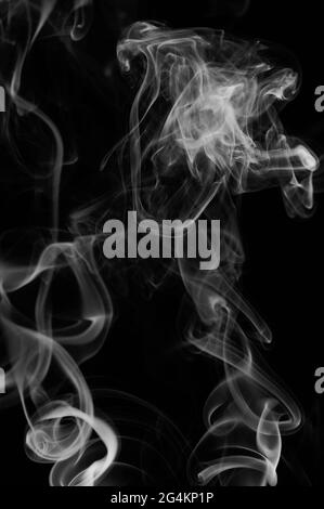 Il fumo bianco ruota su sfondo nero che galleggia nell'aria Foto Stock