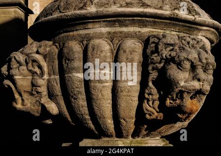 Grottesco muratori scolpiti in pietra o maschere alla fine di dicembre sole sulla fontana dei primi del 18 ° secolo in Place Saint-Siffrein, la piazza prima del 16 ° secolo Flamboyant Gothic Porte des juifs (porta ebraica), il portale sud dell'ex Cathédrale Saint-Siffrein a Carpentras, Vaucluse, Provenza-Alpi-Côte d'Azur, Francia. La fontana fu una delle tante costruite per distribuire abbondante acqua pulita portata da un acquedotto costruito nel 1734. Foto Stock