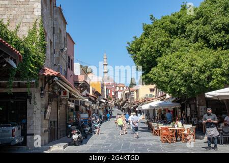 RODI, Grecia - 07 GIUGNO 2021. I turisti camminano lungo i negozi della famosa via Socrate nel centro storico di Rodi. Mercato di strada che conduce al commercio Foto Stock