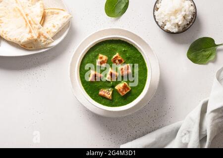 Cucina vegetariana indiana Palak Paneer di spinaci e formaggio paneer con chapati e riso basmati su sfondo bianco. Vista dall'alto. Foto Stock