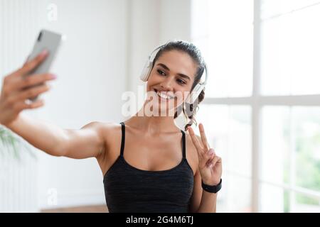 Fitness lady fare selfie foto su smartphone durante la pausa allenamento Foto Stock