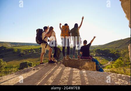 Gruppo di viaggiatori che festeggiano la vittoria in collina Foto Stock