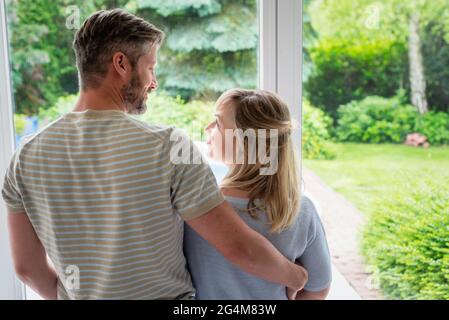 Vista posteriore della coppia che si alza insieme al finestrino e si guarda l'un l'altro. Vibrazioni positive. Foto Stock