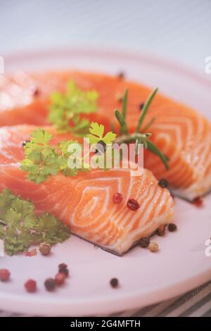 filetto di salmone crudo, pesce crudo, pepe e erbe aromatiche Foto Stock