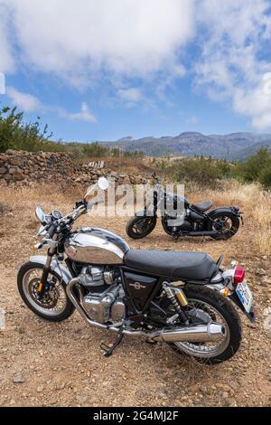 Moto in stile retrò. Triumph Bobber, Royal Enfield 650 Interceptor parcheggiato su terreno accidentato con il Monte Teide alle spalle a Tenerife, Isole Canarie, SPAI Foto Stock