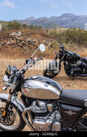 Moto in stile retrò. Triumph Bobber, Royal Enfield 650 Interceptor parcheggiato su terreno accidentato con il Monte Teide alle spalle a Tenerife, Isole Canarie, SPAI Foto Stock