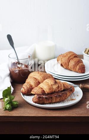 Croissant appena sfornati con crema al cioccolato e nocciole. Foto Stock
