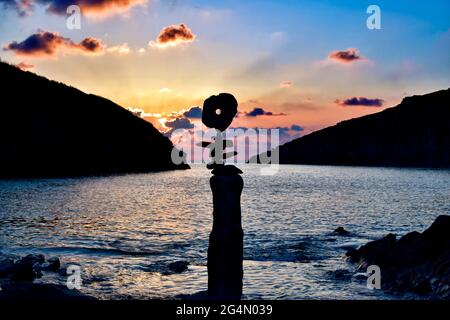 Pietre equilibranti sulla spiaggia di Port Quin al tramonto. Foto Stock