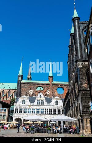 Lübeck, Germania - 24 agosto 2019: Municipio di Lübeck con un bar con terrazza e la gente intorno sulla Piazza del mercato a Lübeck, Germania Foto Stock