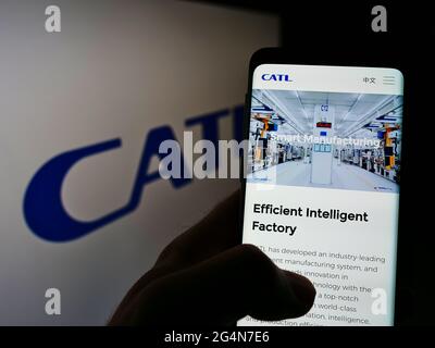 Persona titolare smartphone con sito web di Contemporary Amperex Technology Co. Limited (CATL) su schermo con logo. Mettere a fuoco il centro del display del telefono. Foto Stock