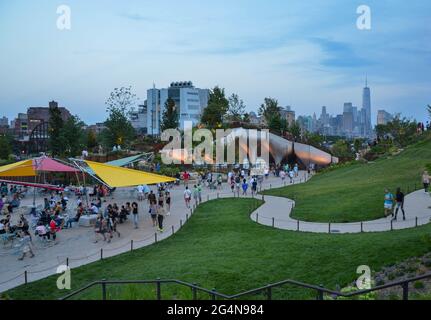 Il più nuovo parco di New York City, "The Little Island" al Pier 55 di Manhattan, è stato inaugurato di recente. Le persone si vedono godendo il pomeriggio estivo presso il parco. Foto Stock