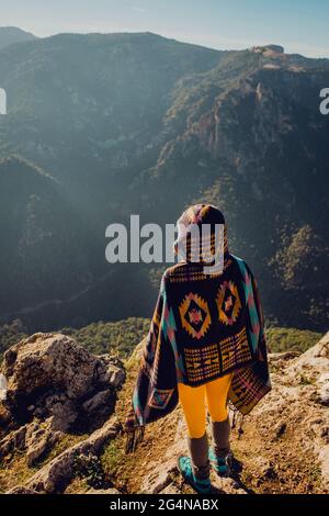 Vista posteriore di un'irriconoscibile esploratrice femminile spensierata che si erge in altipiani e gode di libertà Foto Stock