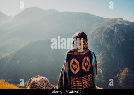 Vista posteriore di un'irriconoscibile esploratrice femminile spensierata che si erge in altipiani e gode di libertà Foto Stock