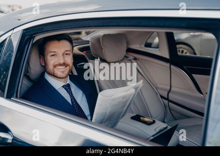 Il proprietario indipendente di affari che legge il giornale in automobile Foto Stock