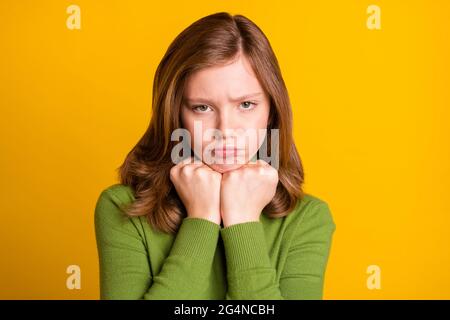 Foto ritratto ragazza triste viso grumpy offeso in abiti verdi isolati vivido sfondo giallo Foto Stock