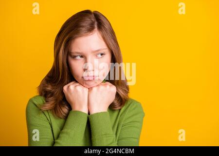 Foto ritratto giovane ragazza in verde turtleneck grumpy guardando copyspace offended isolato vivido sfondo di colore verde Foto Stock