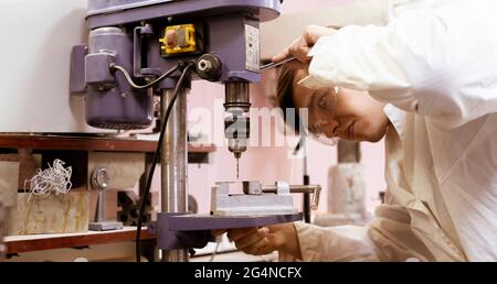 giovane lavoratore industriale maschile che lavora nella fabbrica di produzione, professione industriale Foto Stock