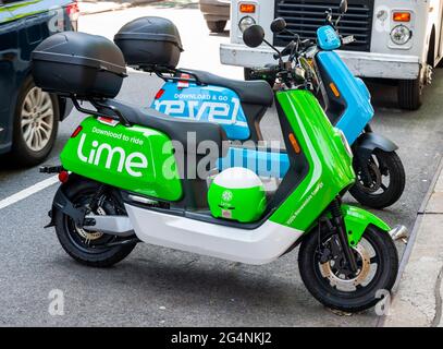 Motorini elettrici con marchio Revel e Lime parcheggiati fianco a fianco nel quartiere Chelsea di New York giovedì 10 giugno 2021. Conosciuto principalmente per il suo kick scooter ride-sharing Lime ha lanciato una linea di ciclomotori elettrici Lime a New York. I ciclomotori sono prodotti dalla società cinese NIU e sono gli stessi veicoli utilizzati dal concorrente di Lime Revel. (© Richard B. Levine) Foto Stock