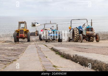 Guardando giù lo scivolo di tre trattori a Crromer come una barca da pesca attende un recupero. Visto nel giugno 2021 sulla costa nord del Norfolk. Foto Stock