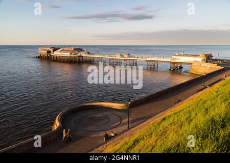 La luce dorata cade sul molo di Cromer una sera nel giugno 2021 sulla costa nord del Norfolk. Foto Stock