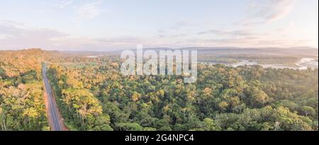 Panorama aereo di un'autostrada Amazzonica in Ecuador con Rio Napo sullo sfondo. Le strade portano alla colonizzazione e distruzione della foresta pluviale Foto Stock