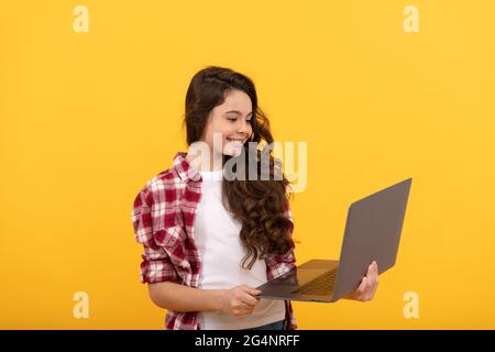 felice bambino intelligente tenere il portatile durante la lezione di scuola online, la scuola Foto Stock