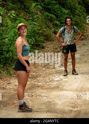 Minca, Magdalena, Colombia - Maggio 19 2021: Donna caucasica con un giovane brasiliano stanno camminando nel mezzo della natura Foto Stock