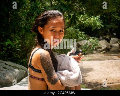 Asian Woman sta asciugando il suo corpo con un asciugamano a Minca, Colombia Foto Stock