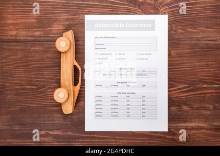 Assicurazione auto e figura auto su sfondo di legno Foto Stock