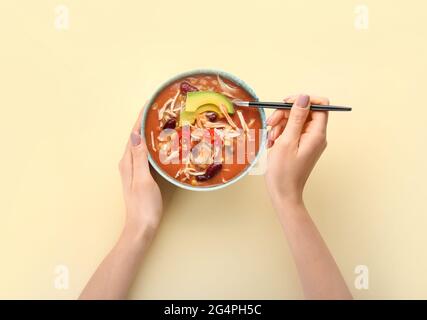 Donna che mangia gustosa zuppa di pollo enchilada dalla ciotola sul tavolo Foto Stock