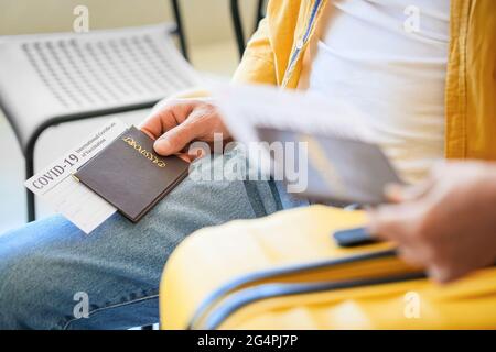 Turisti anziani con passaporti immuni e risultati negativi covid-19 test all'aeroporto, closeup Foto Stock