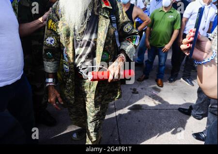 San Salvador, El Salvador. 22 Giugno 2021. Un veterano di guerra tiene in mano un dinamita durante la manifestazione.i veterani della guerra dimostrano al Salvador del Mundo plaza di protestare contro i bassi benefici pensionistici e sanitari forniti dal governo. Credit: SOPA Images Limited/Alamy Live News Foto Stock