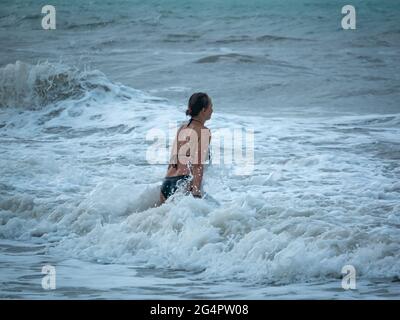 Palomino, Dibulla, la Guajira, Colombia - 24 2021 maggio: Donna caucasica che entra a poco a poco nelle acque più profonde del mare in attesa del Wa Foto Stock