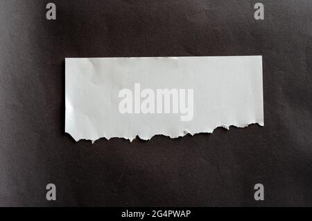 Foglio bianco vuoto con linguette strappate su sfondo grigio. Foglio sgualcito. Tutte le linguette sono strappate. Concetto di annuncio di Lucky Street. Foto Stock