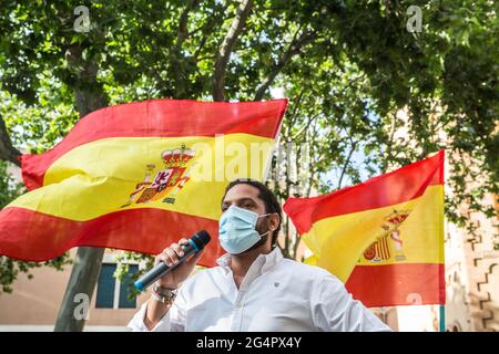 Barcellona, Spagna. 22 Giugno 2021. Ignacio Garriga, deputato del Parlamento della Catalogna per il partito di estrema destra spagnolo, Vox parla ai sostenitori, sullo sfondo le bandiere spagnole sono viste durante la protesta. Il partito di estrema destra spagnolo, Vox, insieme al partito politico, Ciudadanos, hanno indetto una manifestazione in Piazza Artos di Barcellona, luogo regolare per i raduni di estrema destra, Contro il presidente del governo spagnolo, Pedro Sanchez, per la decisione di perdonare i prigionieri politici catalani di indipendenza. Credit: SOPA Images Limited/Alamy Live News Foto Stock