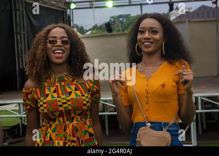 Coppia di ragazze nigeriane che sorridono felicemente in un concerto serale Foto Stock