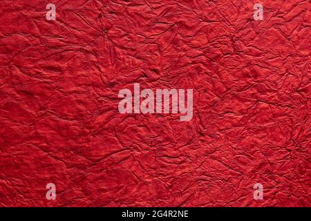 Sfondo con carta schiacciata di colore rosso Foto Stock
